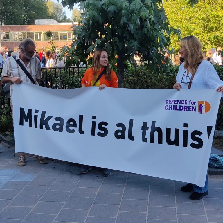 Supporters houden banner vast met daarop de tekst Mikael is al thuis! Kinderpardon NU